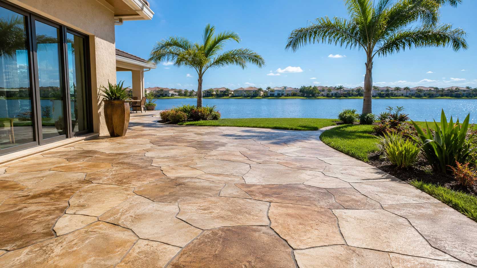 Concrete overlay patio with a tan stamped flagstone finish overlooking a lake in Palm Beach and Broward County
