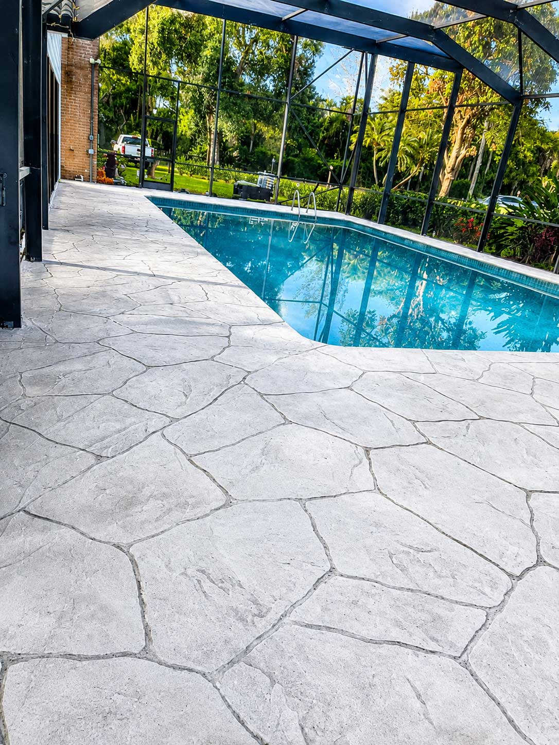 Light gray stamped concrete pool deck with a flagstone pattern in Palm Beach and Broward County