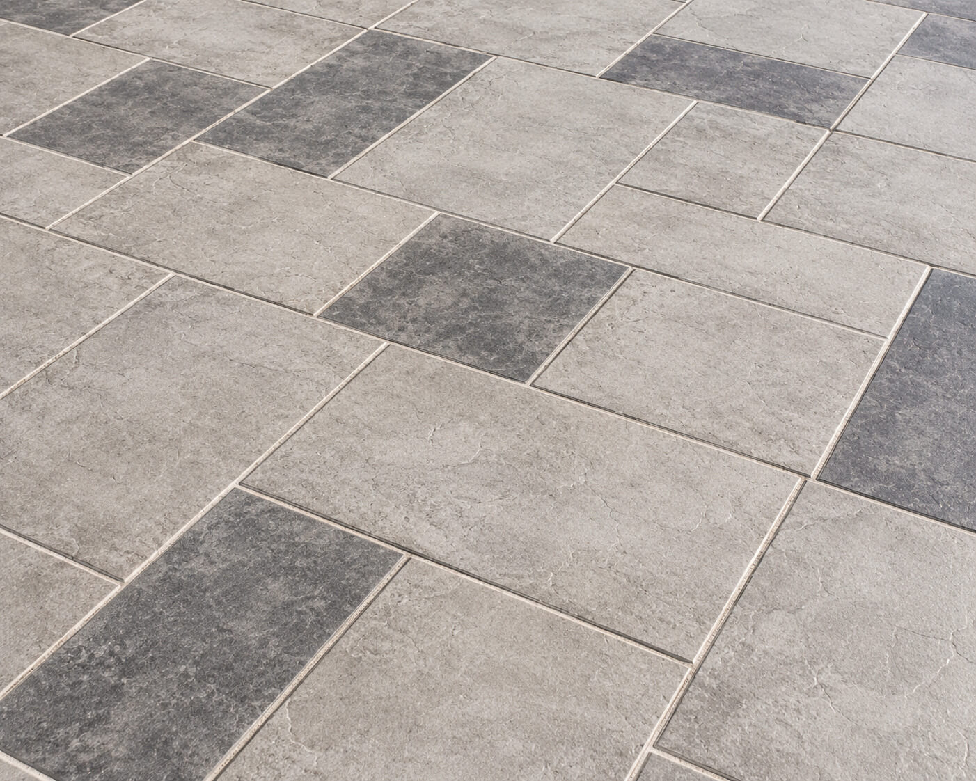 Gray modular tile driveway overlay in a grid pattern