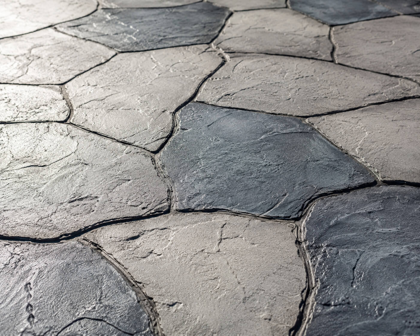 Gray stamped concrete driveway overlay with an irregular flagstone pattern