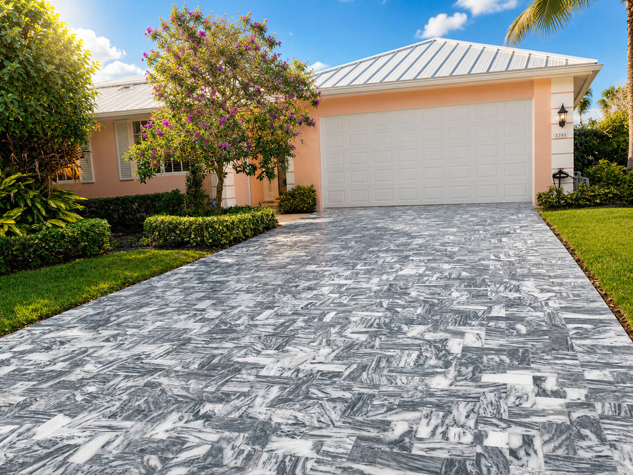 Gray veined marble driveway in herringbone leading to the garage of a coral home for a Juno Beach homeowner