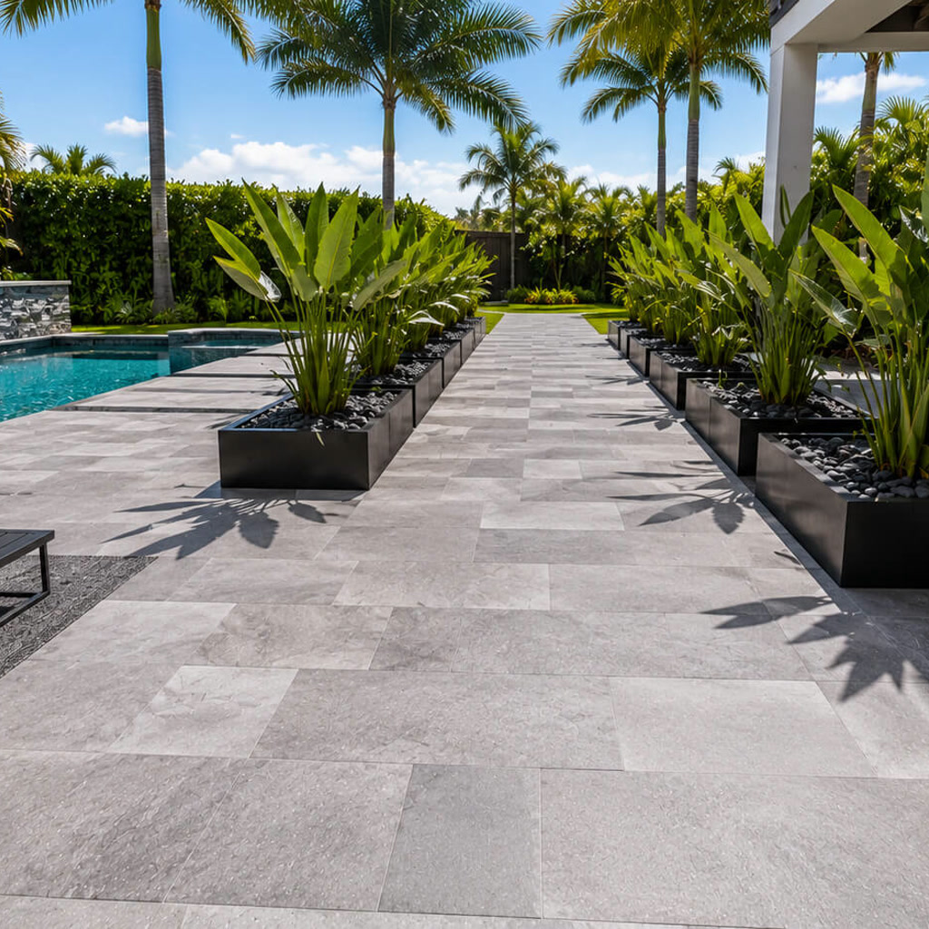 Gray paver walkway running between black planters to connect the pool deck with the rest of the backyard in Juno Beach