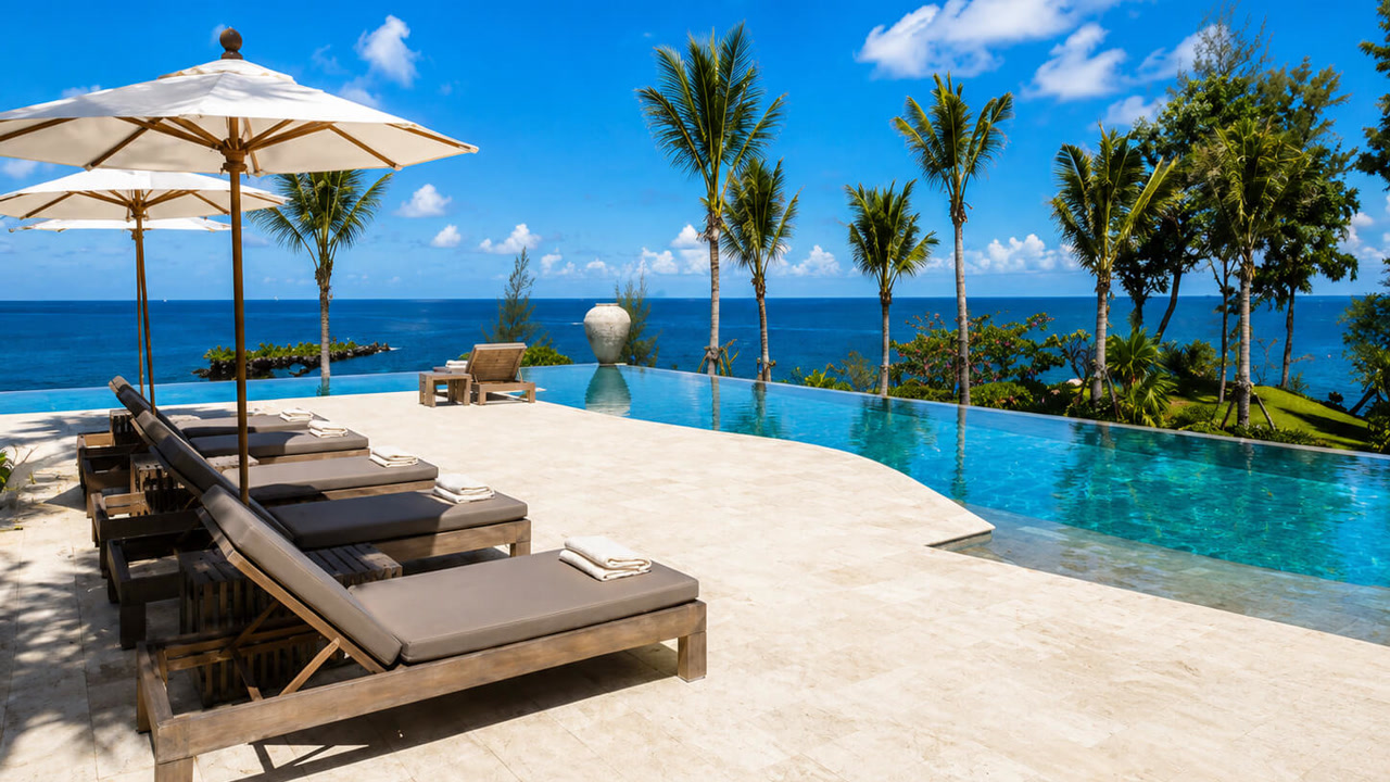 Renovated travertine paver pool deck around an infinity edge pool with an ocean view at a Gulfstream residence