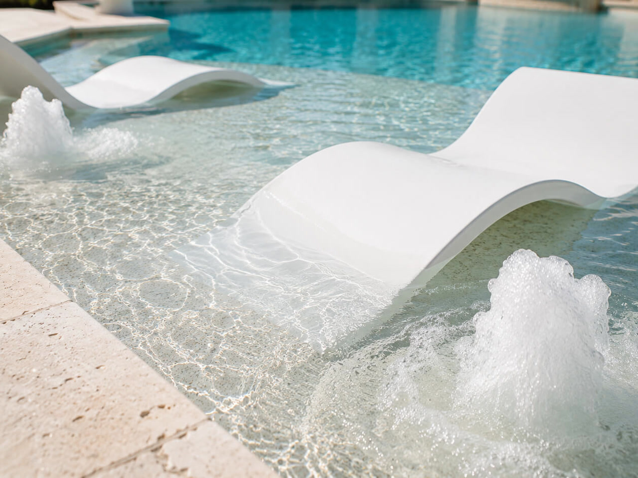 White in water loungers on a shallow sun shelf with bubblers churning on either side